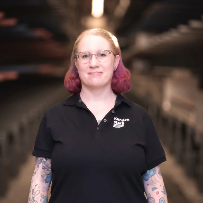 Mitarbeiterin im Lager Frau im Stark-AG-Poloshirt steht in einem Lager.