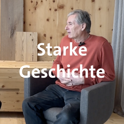 Holzhandel im Fokus Ein Mann sitzt vor einer Holzvertäfelung in einem Sessel und spricht.