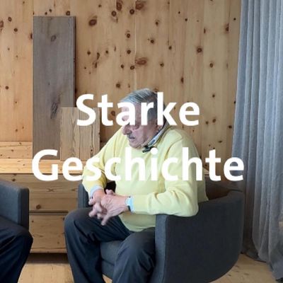 Starke Geschichte Ein Mann in einem Gespräch, untermalt von einer Holz- und Stoffkulisse, mit dem Text 'Starke Geschichte'.