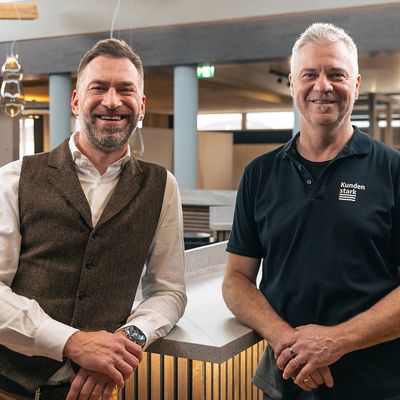 Holzhändler Stark AG Zwei Männer in einem modernen Innenausbauraum der Stark AG Altstätten lächelnd stehend.